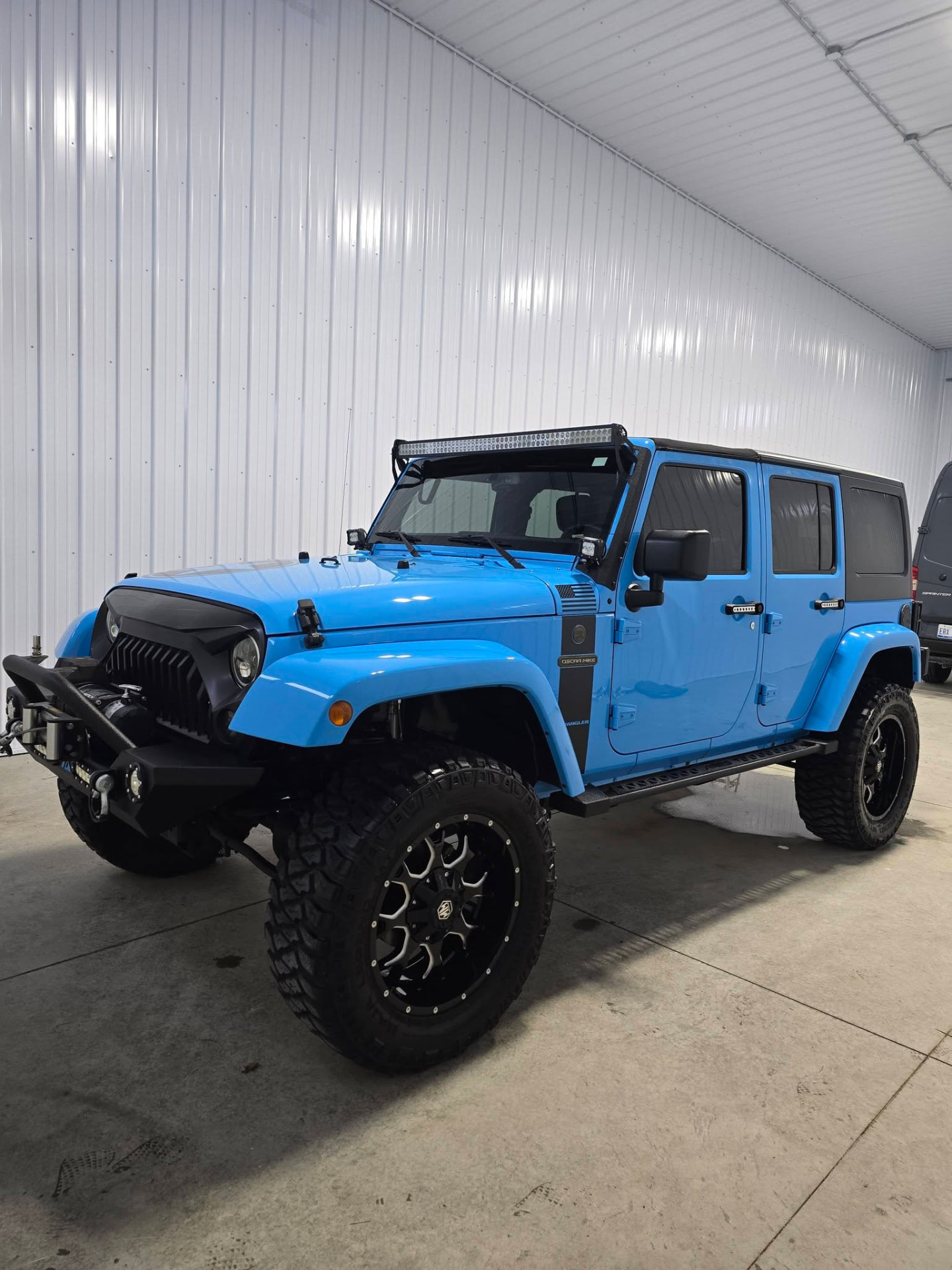 Light blue lifted Jeep Wrangler with a glossy finish after detailing