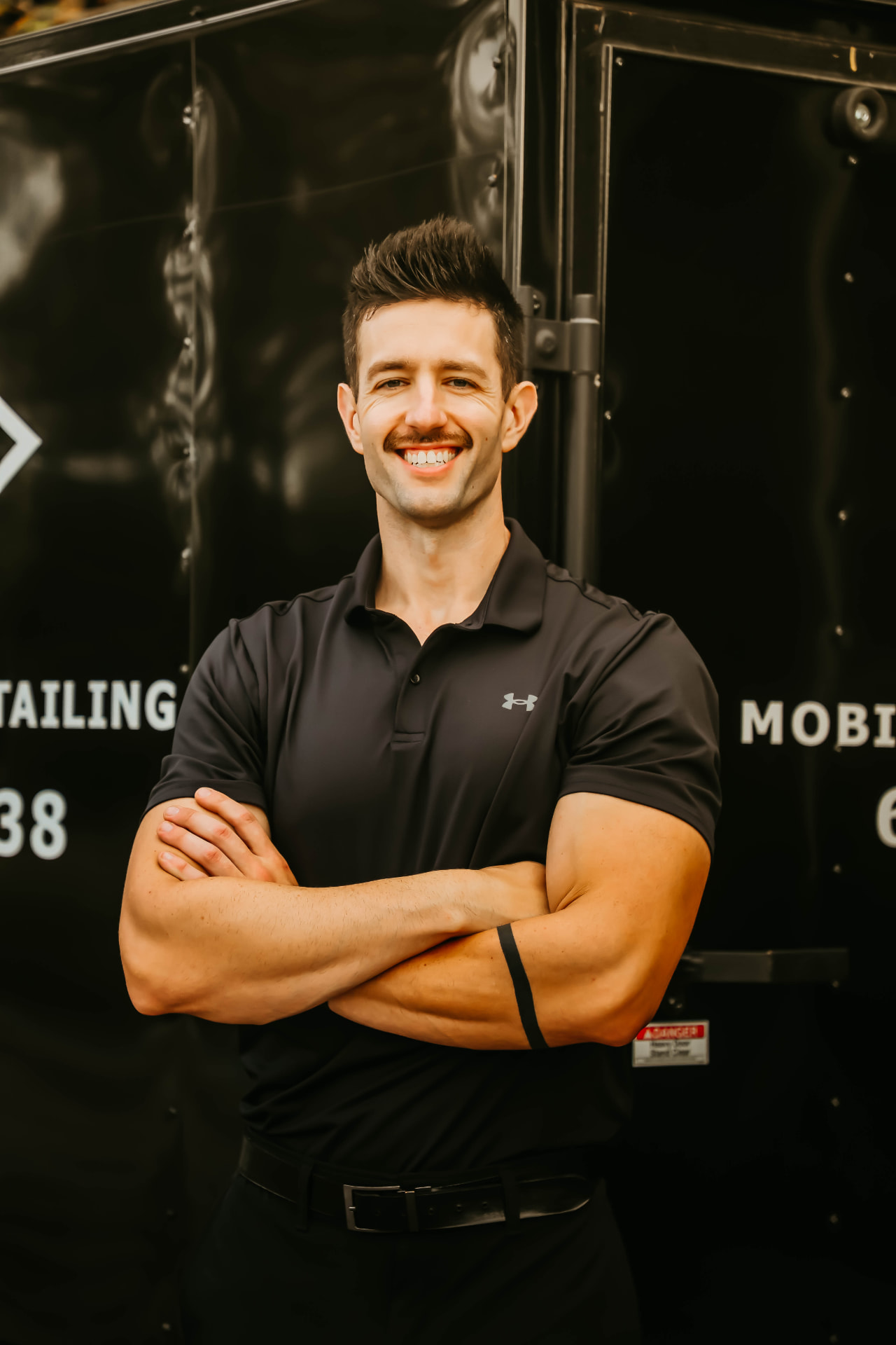 The owner of Mobile Master Detailing in front of the MMD trailer